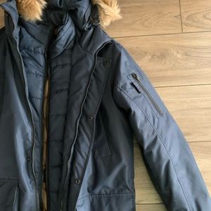 Navy blue jacket with inside pocket and arm pocket.